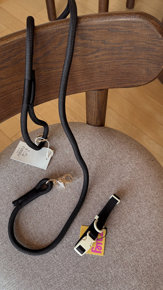 Black Furlou dog leash and Fritz collar on a chair with a visible brand tags.