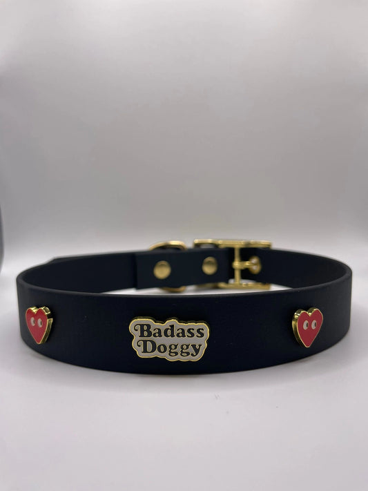 Black dog collar with 'Badass Doggy' plaque and heart charms on a white background