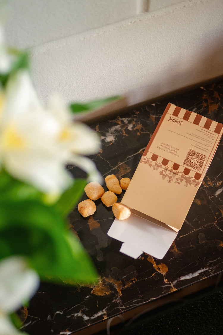 Cheese snacks on a marble surface with a blurred flower in the foreground