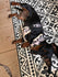 Small dog wearing a cocopup patterned harness on a decorative tile floor