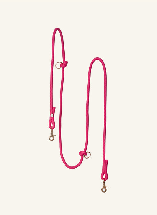 Dark pink Furlou leash with gold hardware on a white background