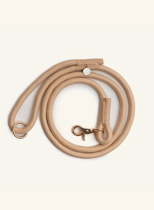 Beige dog leash with brass hardware from Furlou on a white background